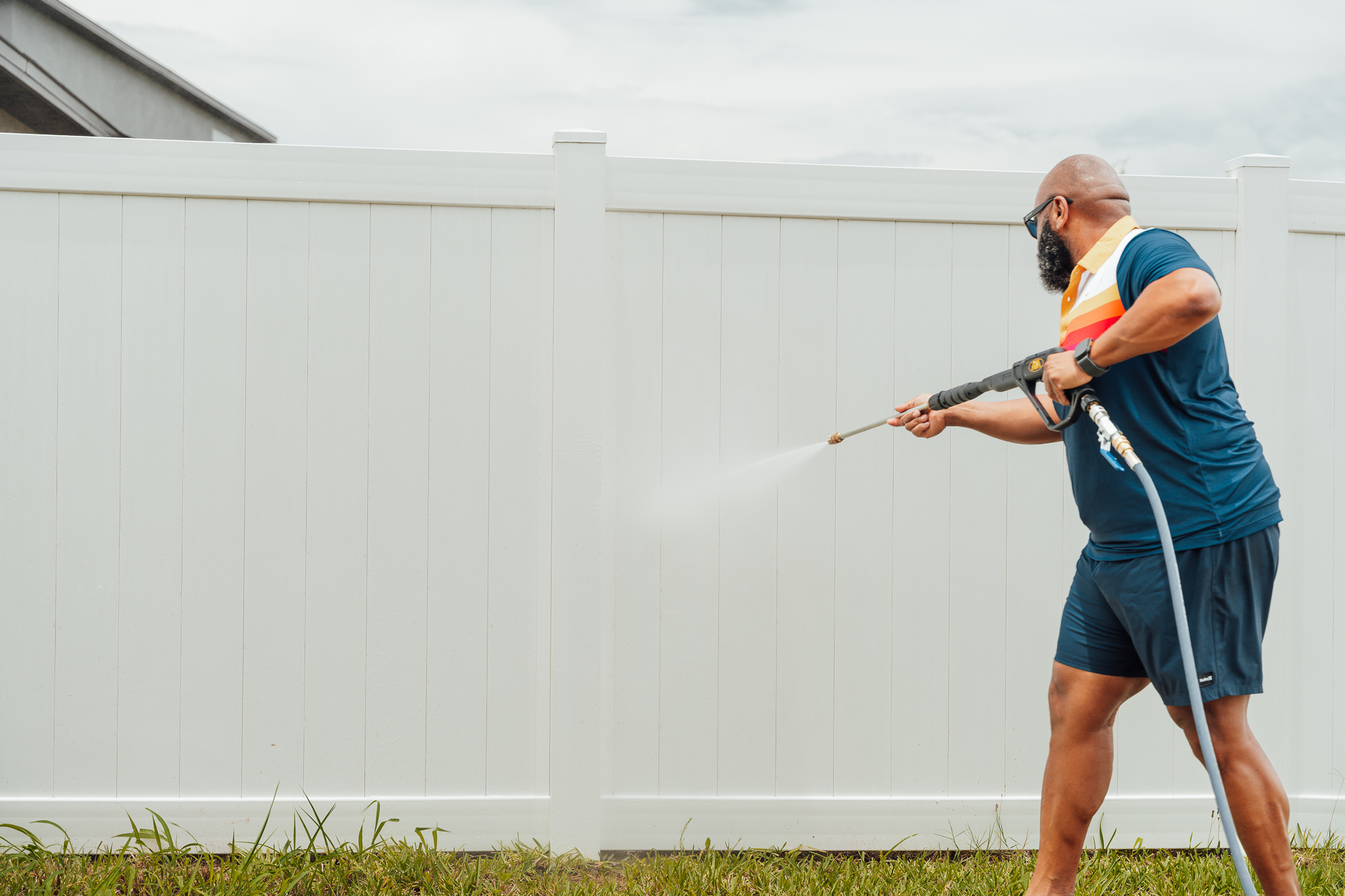 Lakeland Clean Dreams owner softwashing a white vinyl fence in Lakeland, FL